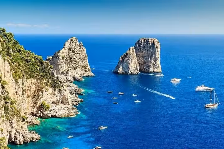 Stunning view of Capri's Faraglioni rock formations surrounded by azure sea, perfect for Amalfi coast tours.