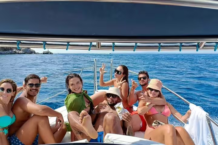 Group of friends relaxing on a private boat near Capri Island on a sunny day
