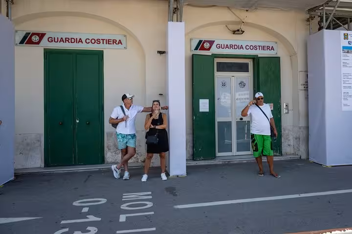 People standing outside the Guardia Costiera building, part of the guided island exploration on Capri tour.