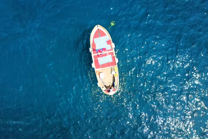 Aerial view of classic boat on sparkling blue water during Capri Essence 4h private boat tour