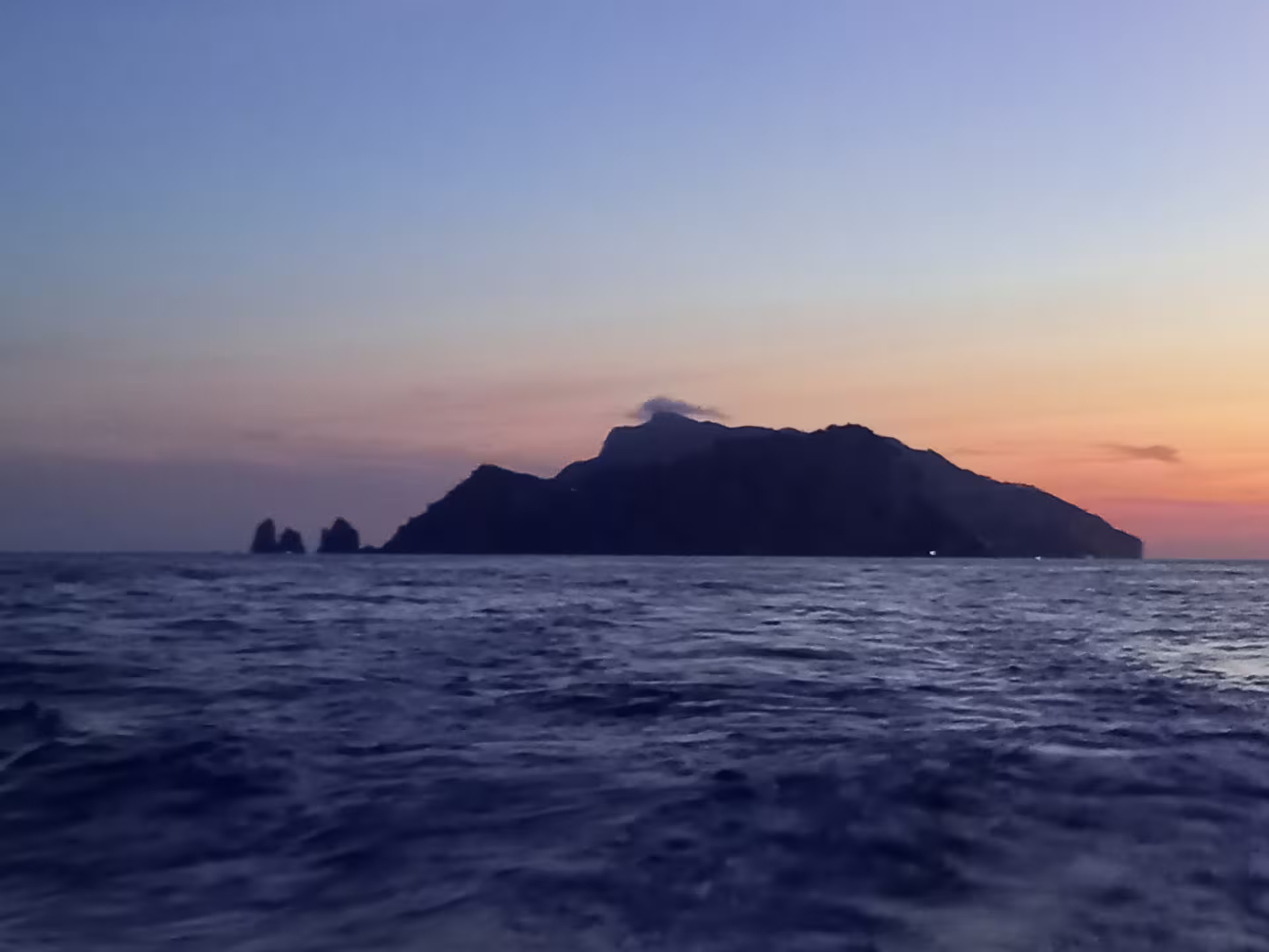 Twilight island silhouette across the sea at dusk, From Dusk Till Night immersive experience in the world of the night