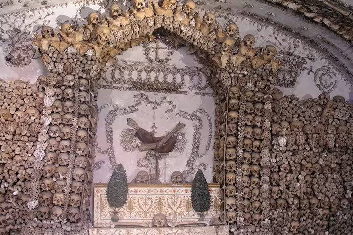 Bone archway in Rome's Capuchin Crypt showcasing skulls and artistic bone arrangements for macabre tours.