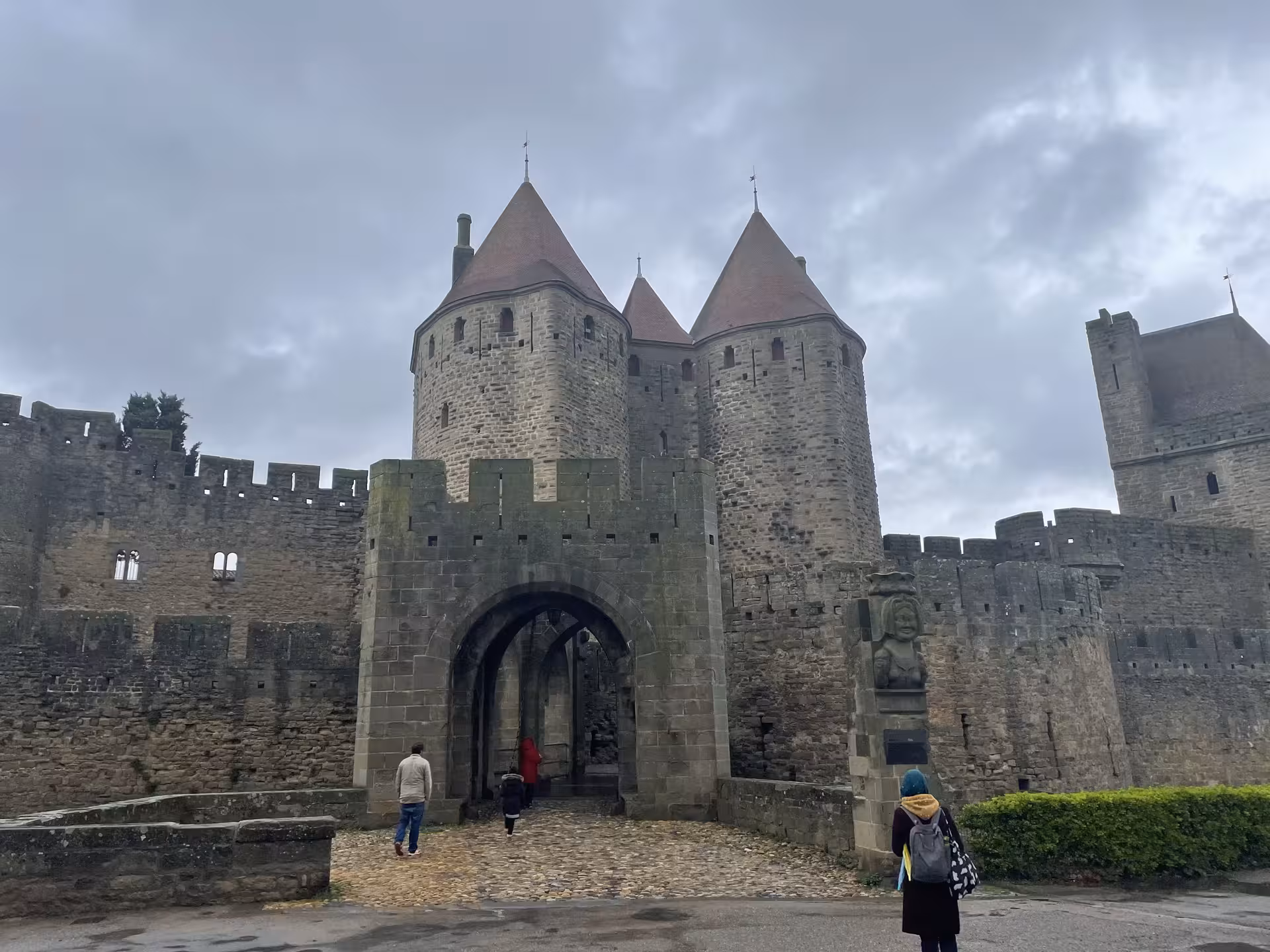Visitors entering Carcassonne fortified gate on private shore excursion from Sète, day trip to Narbonne