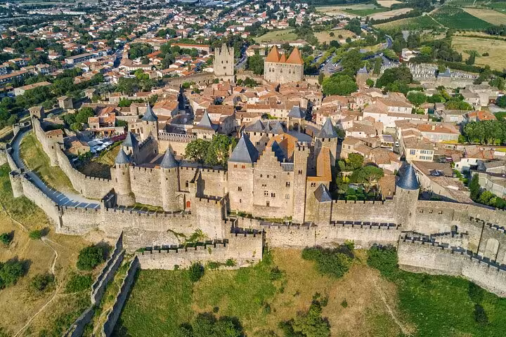 Aerial view of Carcassonne's medieval fortress, highlighting its impressive walls and towers for guided walking tours.