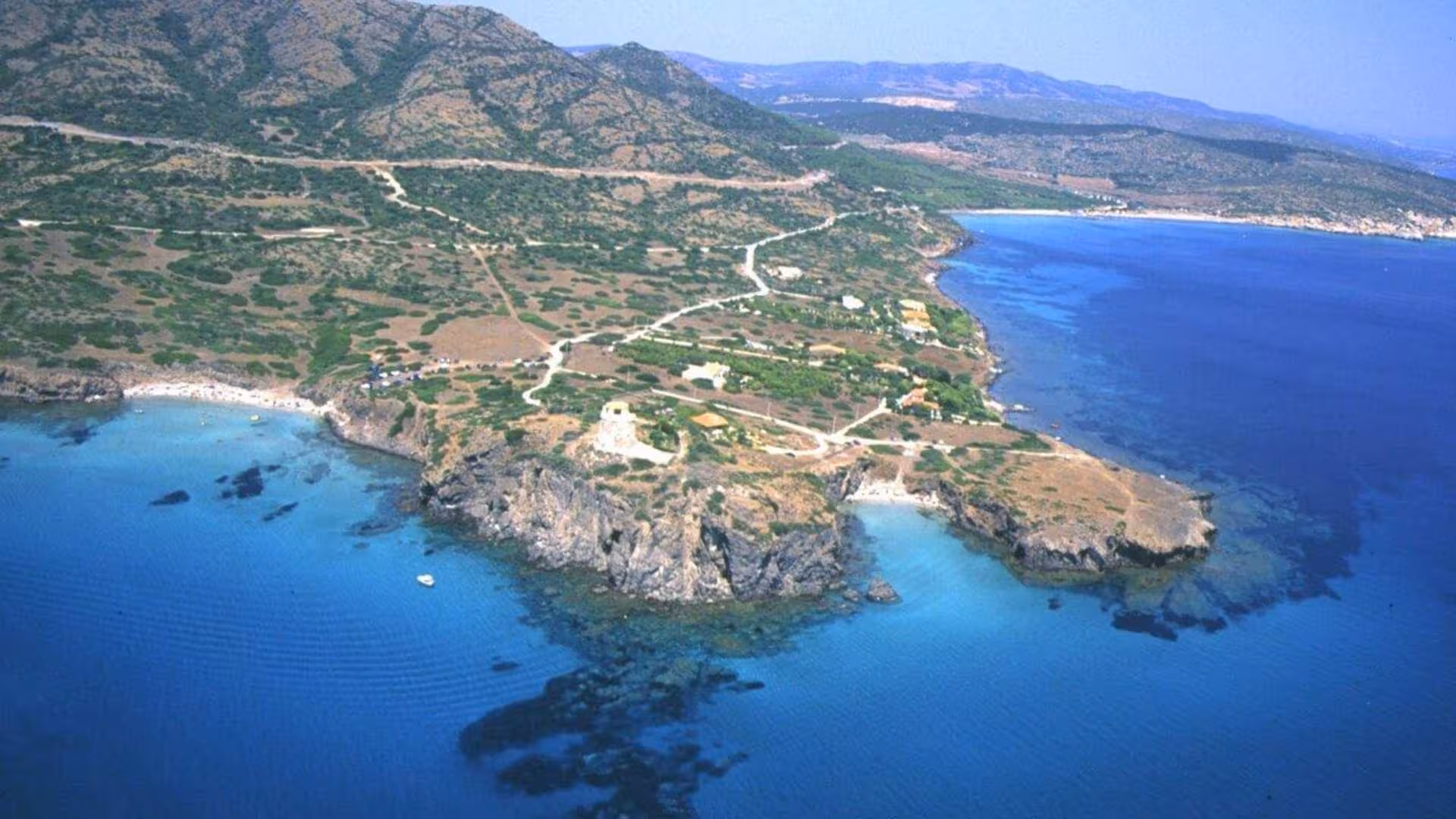 Stunning coastal landscape with rocky cliffs and clear blue sea near Carloforte, perfect for exploring on a dinghy tour.