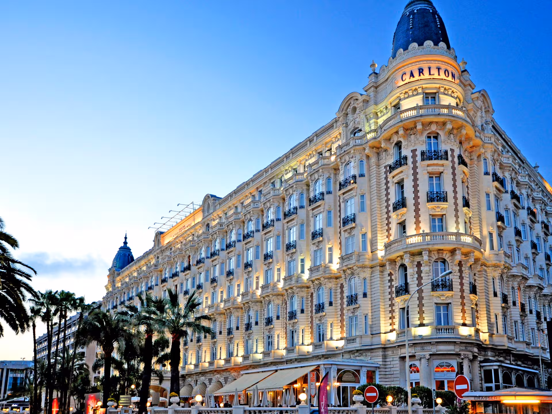 Carlton Hotel facade illuminated at dusk on the French Riviera in Cannes