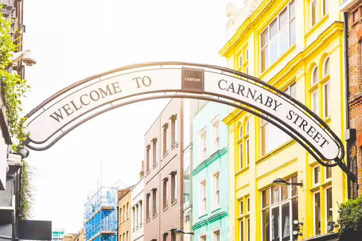 Welcome to Carnaby Street arch sign with colorful buildings in Soho, London