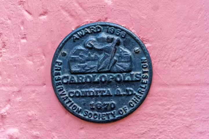 Carolopolis Award medallion from Preservation Society of Charleston, founded 1670, mounted on pink wall