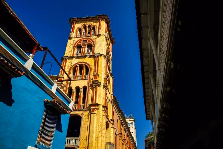 Ornate yellow colonial bell tower rising above colorful streets in historic Cartagena, Colombia