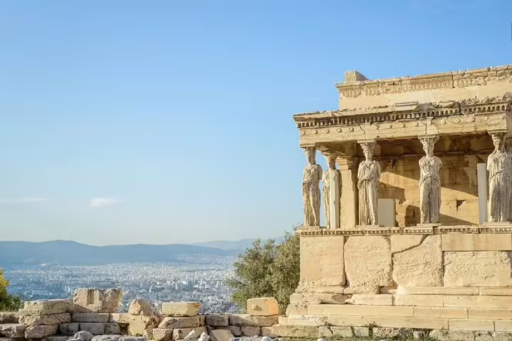 Caryatids at the Erechtheion on the Acropolis, Athens, seen on a French guide walking tour with skyline view