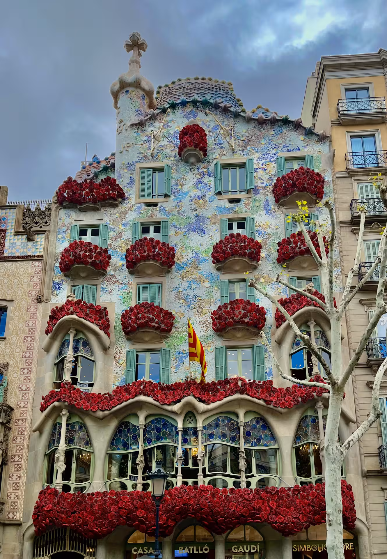 Casa Batlló Gaudí facade in Barcelona with red rose balconies, iconic sight on Encantos Locales + Tablao Flamenco