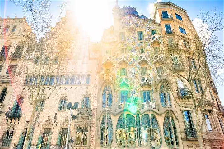 Sunlit facade of Casa Batlló in Barcelona, highlighting Gaudí's unique architectural style and vibrant colors.