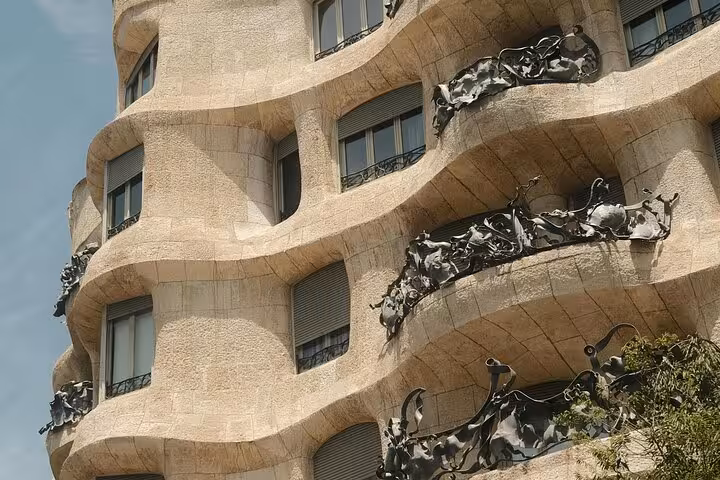 Explore the wavy stone facade of Casa Milà on a private Barcelona car tour, showcasing Gaudí's architectural genius.