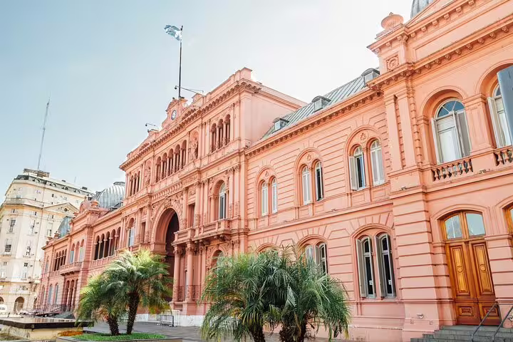 Pink facade of Casa Rosada presidential palace in Buenos Aires with palm trees and arched windows