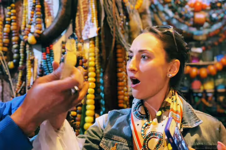 Traveler sampling local food in Casablanca souk with colorful beads, part of a private guided day trip experience