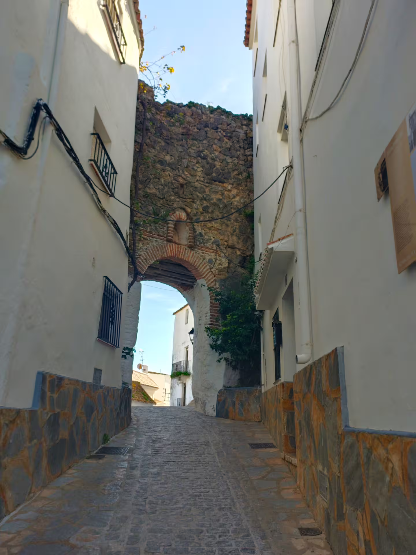 Narrow Casares alley with historic stone arch on Casares and Estepona private trip with hotel pick-up