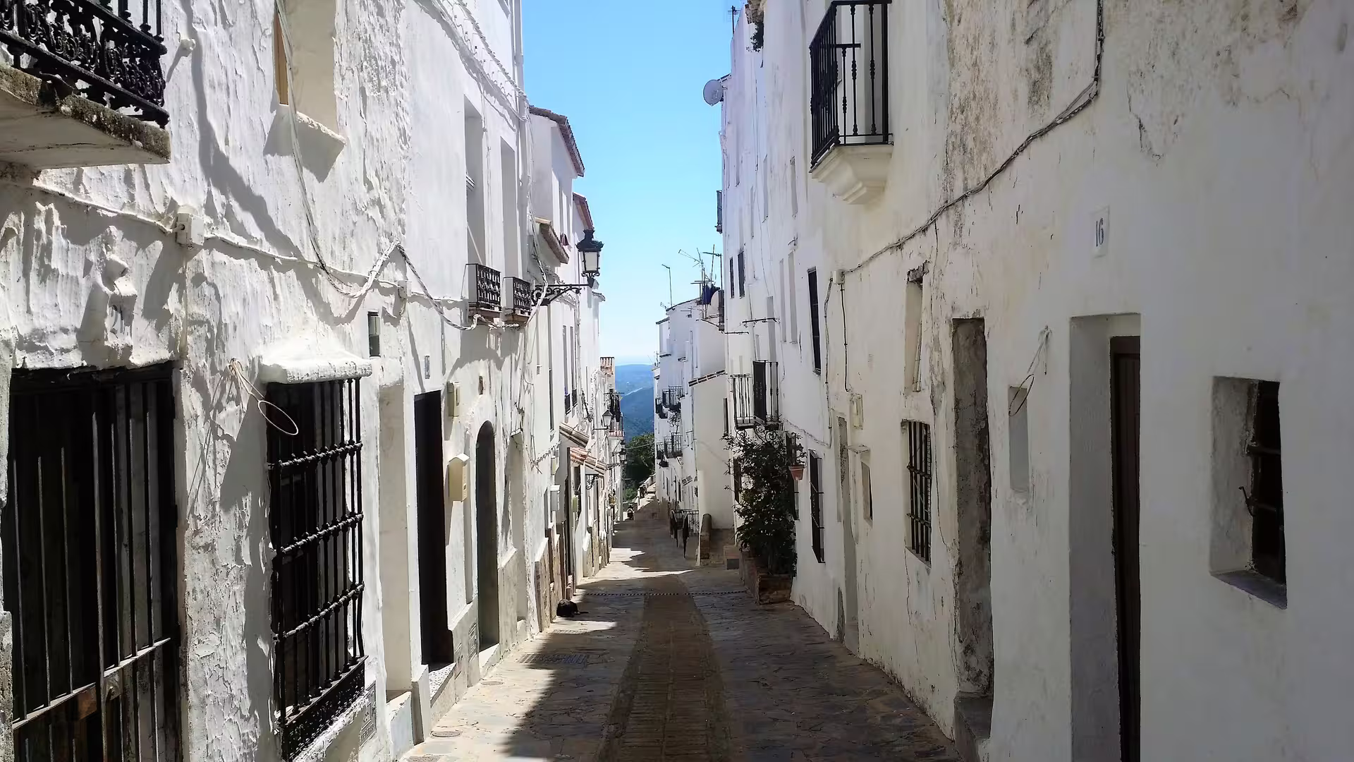 Whitewashed Casares village street with Andalusian balconies, scenic walk on private Casares and Estepona trip