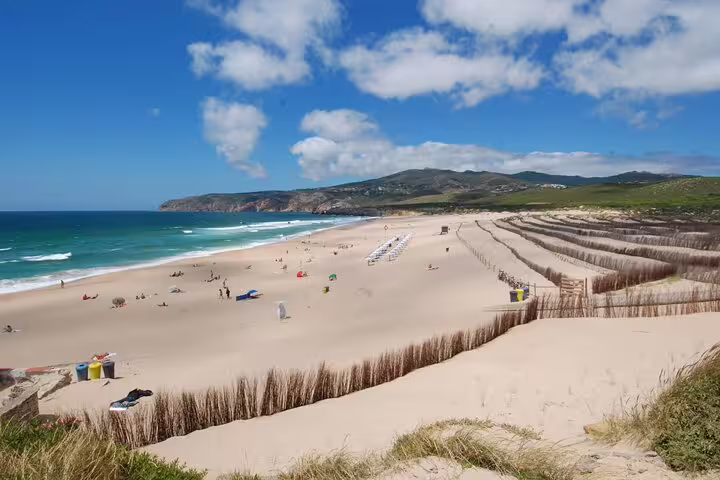 Expansive sandy beach at Cascais with clear blue skies, a highlight of the Lisbon guided day tour.