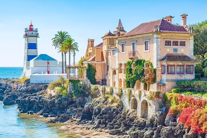 Charming coastal Cascais with lighthouse and colorful buildings, essential stop on Lisbon's guided day tour.