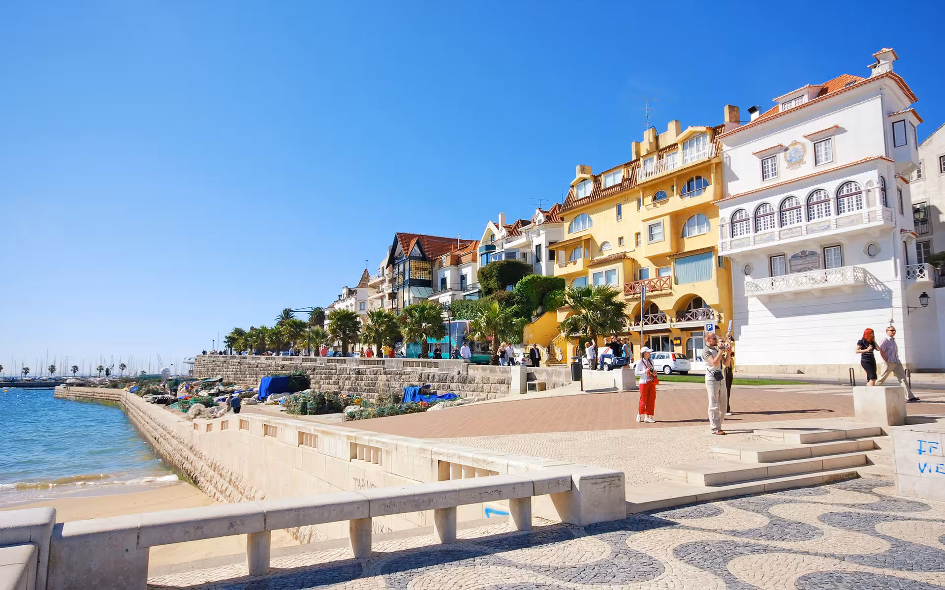 Charming Cascais promenade with colorful buildings and palm-lined streets, a must-visit on your Lisbon tour.