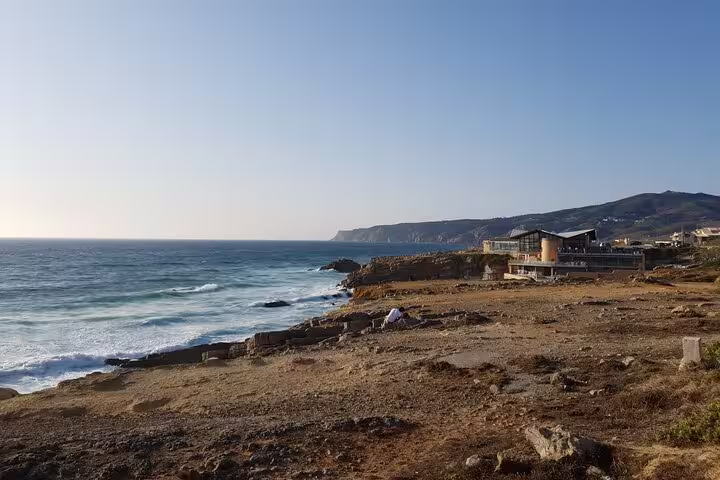 Scenic coastal view of rocky shores and ocean waves near Cascais, highlighted in the Sintra small-group tour.