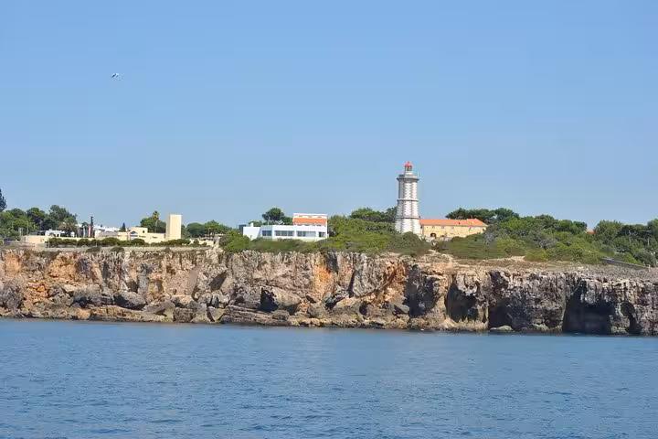 Santa Marta Lighthouse and rocky coastline near Cascais seen from a private sailing cruise on the Atlantic