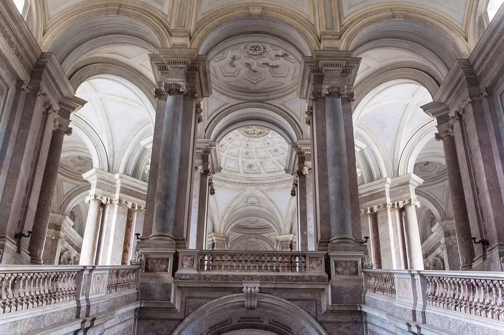 Majestic interior of Caserta Palace with grand arches and columns, highlighting the opulent architecture on Naples day trip.