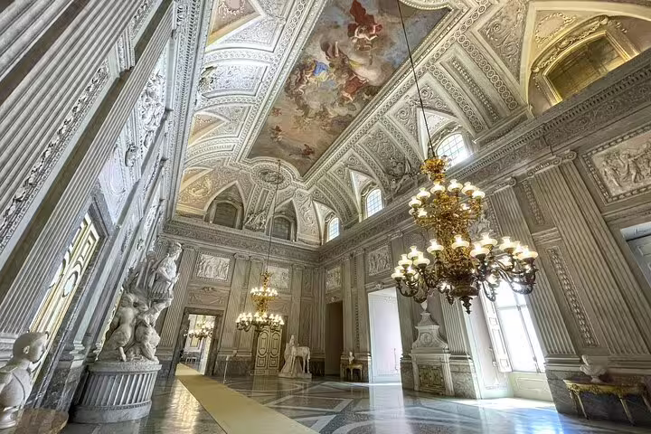 Lavish hall of Caserta Royal Palace with marble columns, chandeliers and frescoed vaults on a private guided tour with shuttle