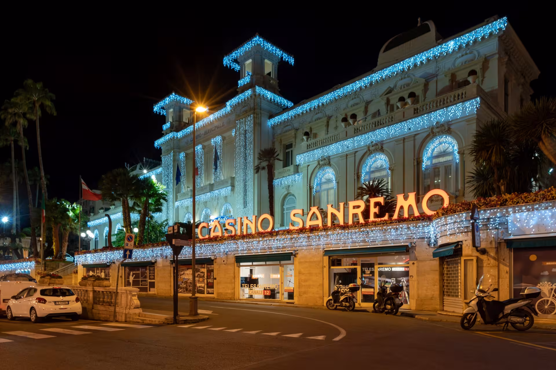Casino Sanremo illuminated with blue lights at night, ornate Belle Époque façade in San Remo, Italy