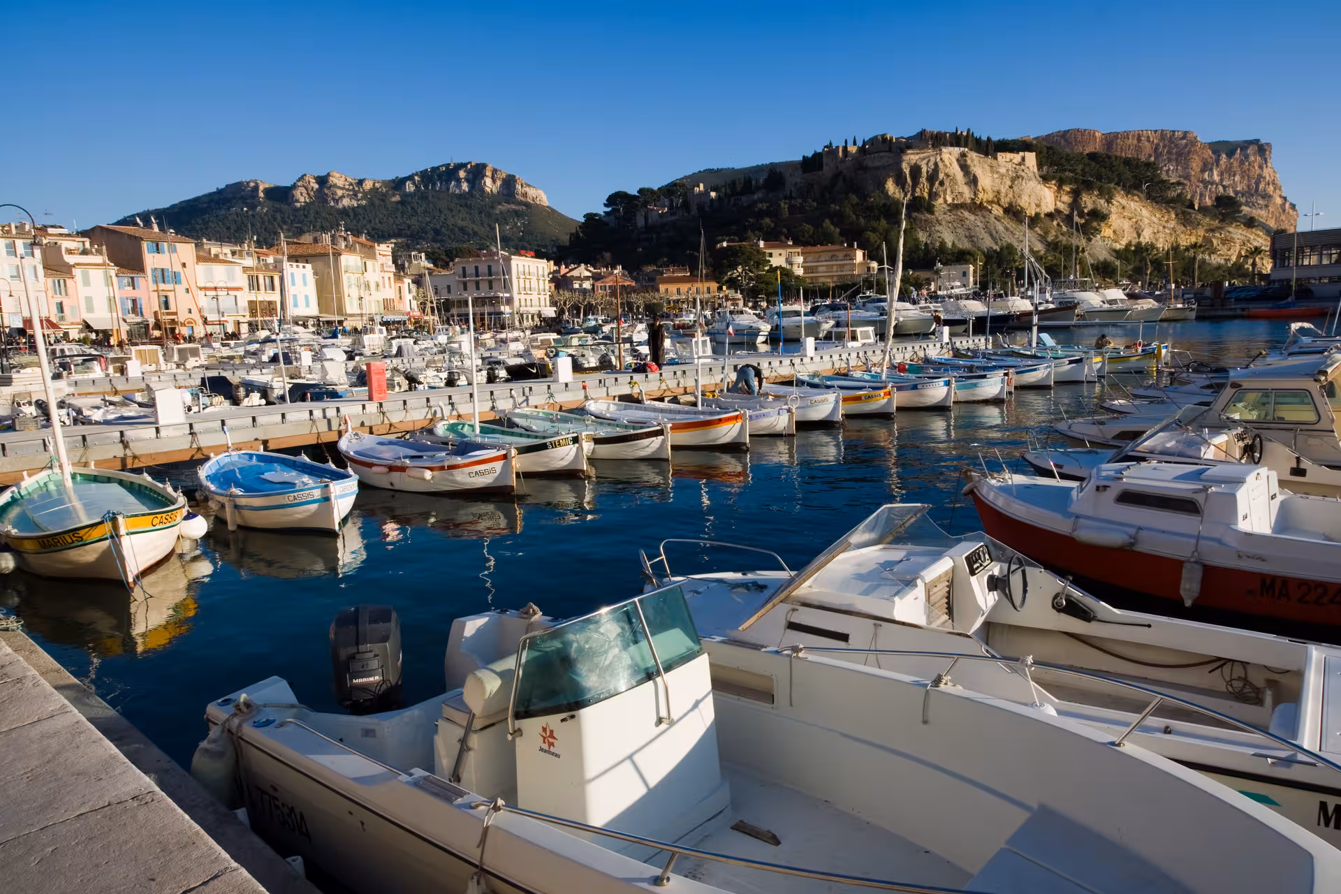 Cassis harbor with colorful boats and pastel waterfront, scenic stop on private day trip from Marseille