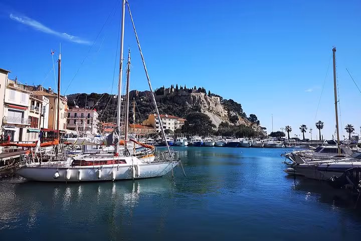 Cassis marina with yachts and cliff views, featured on Arles shore excursion to Aix-en-Provence and Cap Canaille