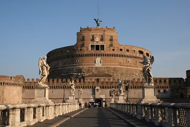 Front view of Castel Sant'Angelo with statues lining the bridge, highlighting its majestic Roman architecture at sunset.