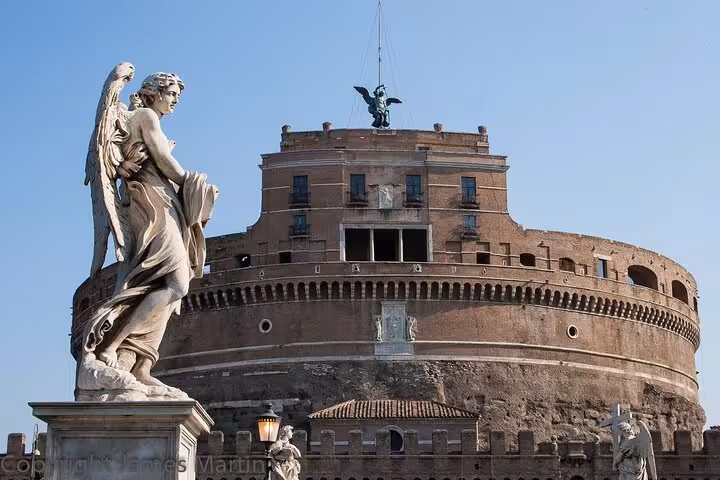 View of Castel Sant'Angelo with angel statue under a clear sky, highlighting historic architecture and Roman heritage.