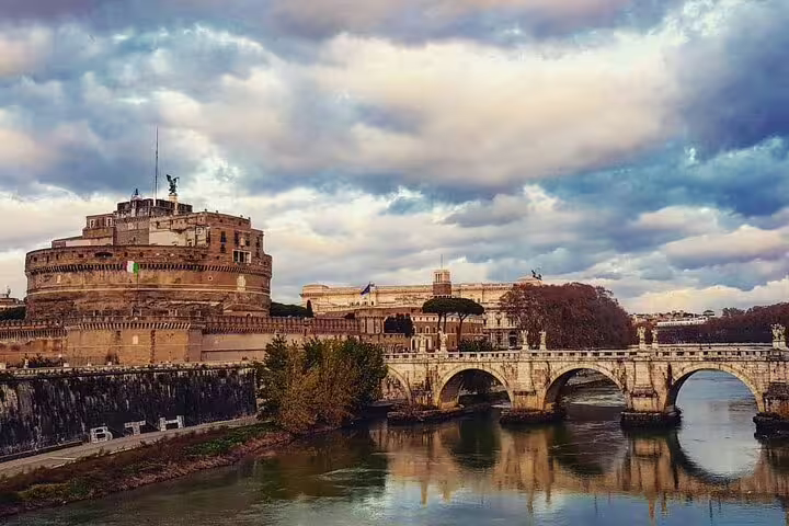 Castel Sant’Angelo and Ponte Sant’Angelo reflected in the Tiber River at sunset on Rome St Peter’s Basilica combo tour