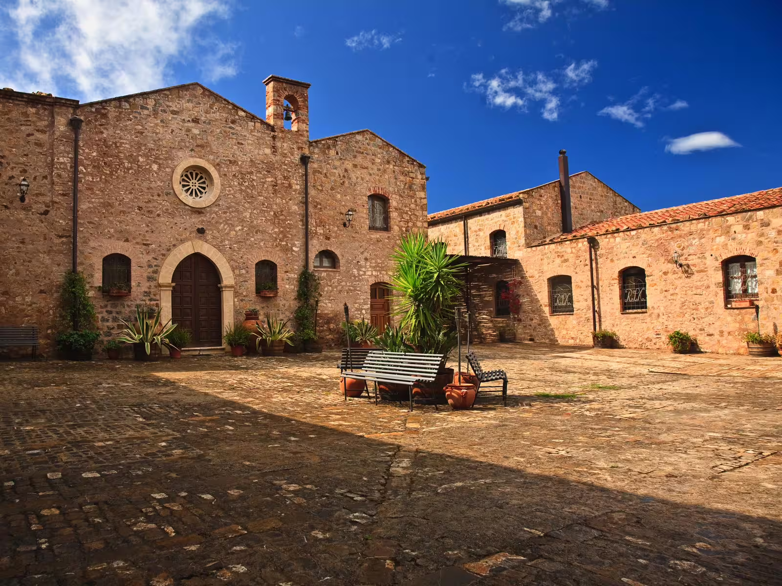 Stone courtyard and church facade in Castelbuono on Cefalù and Castelbuono tour, Sicily wine experience option