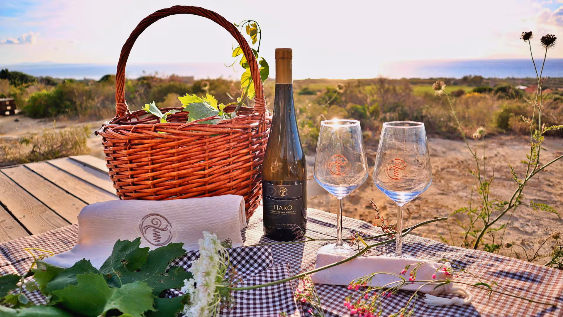 Idyllic picnic setup with wine and glasses overlooking the stunning sea view at a Castelsardo estate.