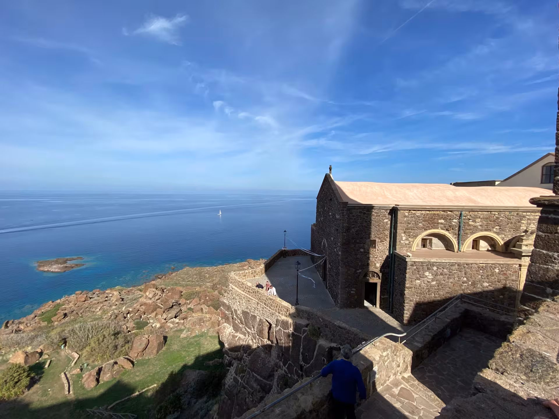 Panoramic view of Castelsardo's historic architecture overlooking the vibrant blue Mediterranean Sea.