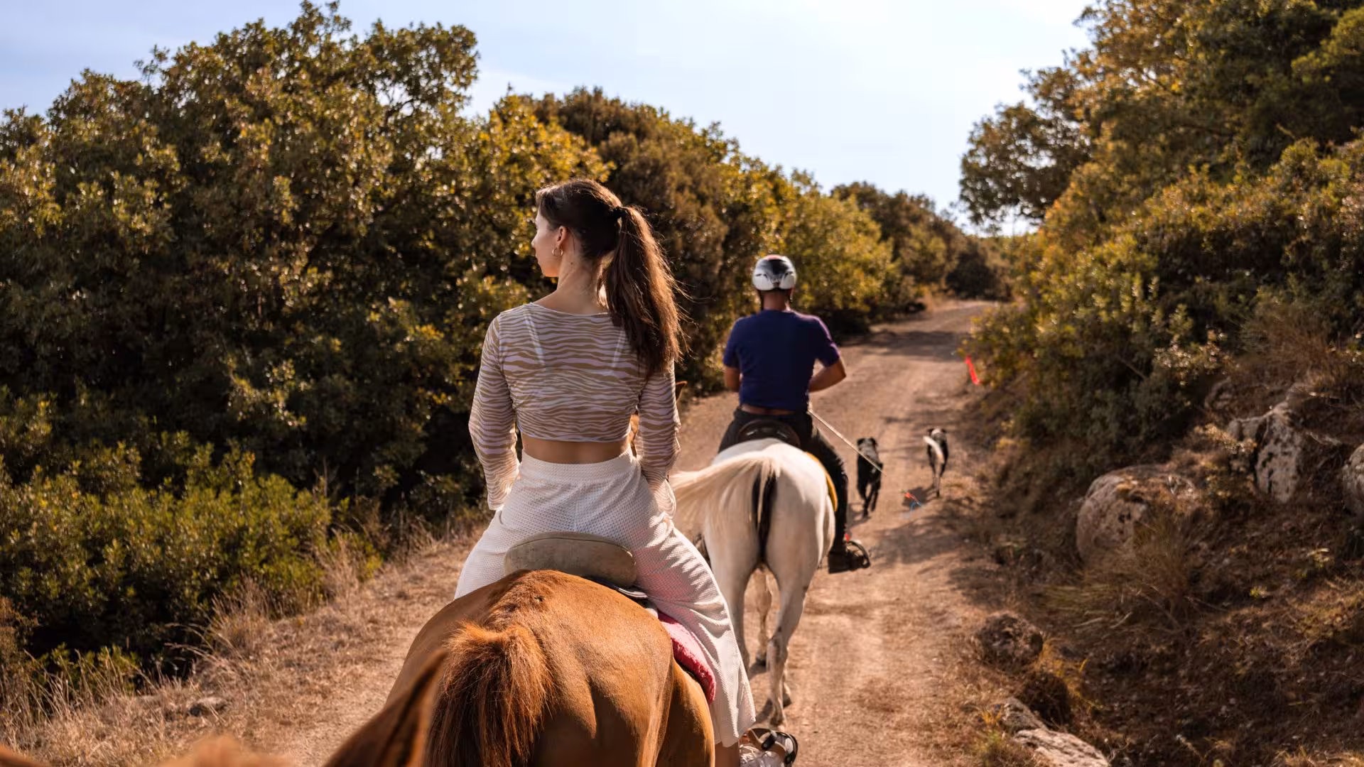 Riders enjoying a horseback tour through Sedini's picturesque trails surrounded by vibrant greenery near Castelsardo.
