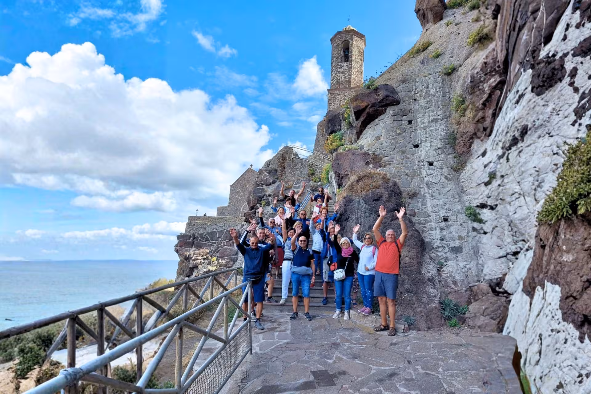 Group of tourists enjoying scenic coastal views from Castelsardo's historic pathways during a guided tour.