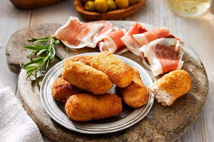 Savor authentic Catalan croquettes and cured ham in Barcelona's Gràcia district on a hidden local food tour.