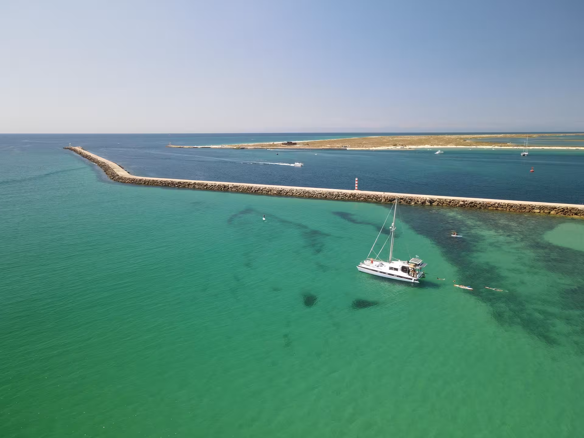 A white catamaran anchored in crystal-clear turquoise Blue Lagoon Atlantic waters during a scenic full-day boat tour.