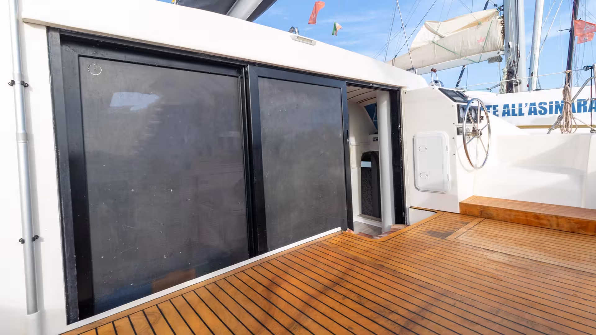 Catamaran's sleek interior with polished wooden deck, offering comfort for Asinara Island tour from Stintino.