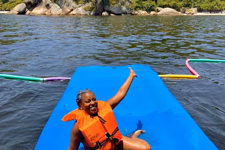 Guest in life jacket enjoying a sea swim stop during Velas do Rio catamaran tour with open bar in Rio