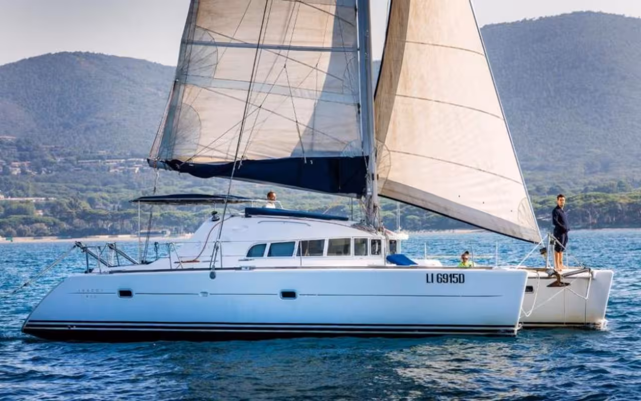 Sailing catamaran cruising among the scenic islands of La Maddalena Archipelago from Cannigione.