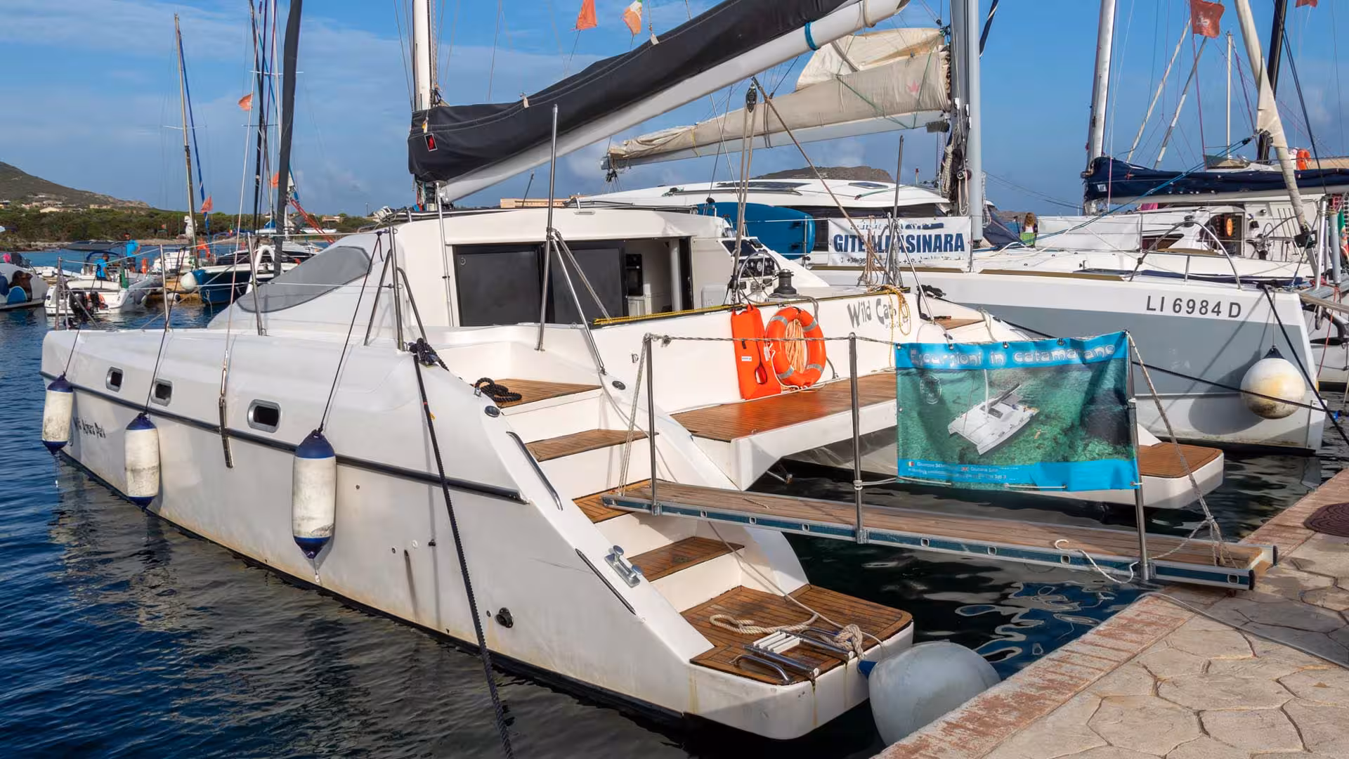 Elegant catamaran moored at Stintino, showcasing spacious decks and ready for Asinara Island exploration.