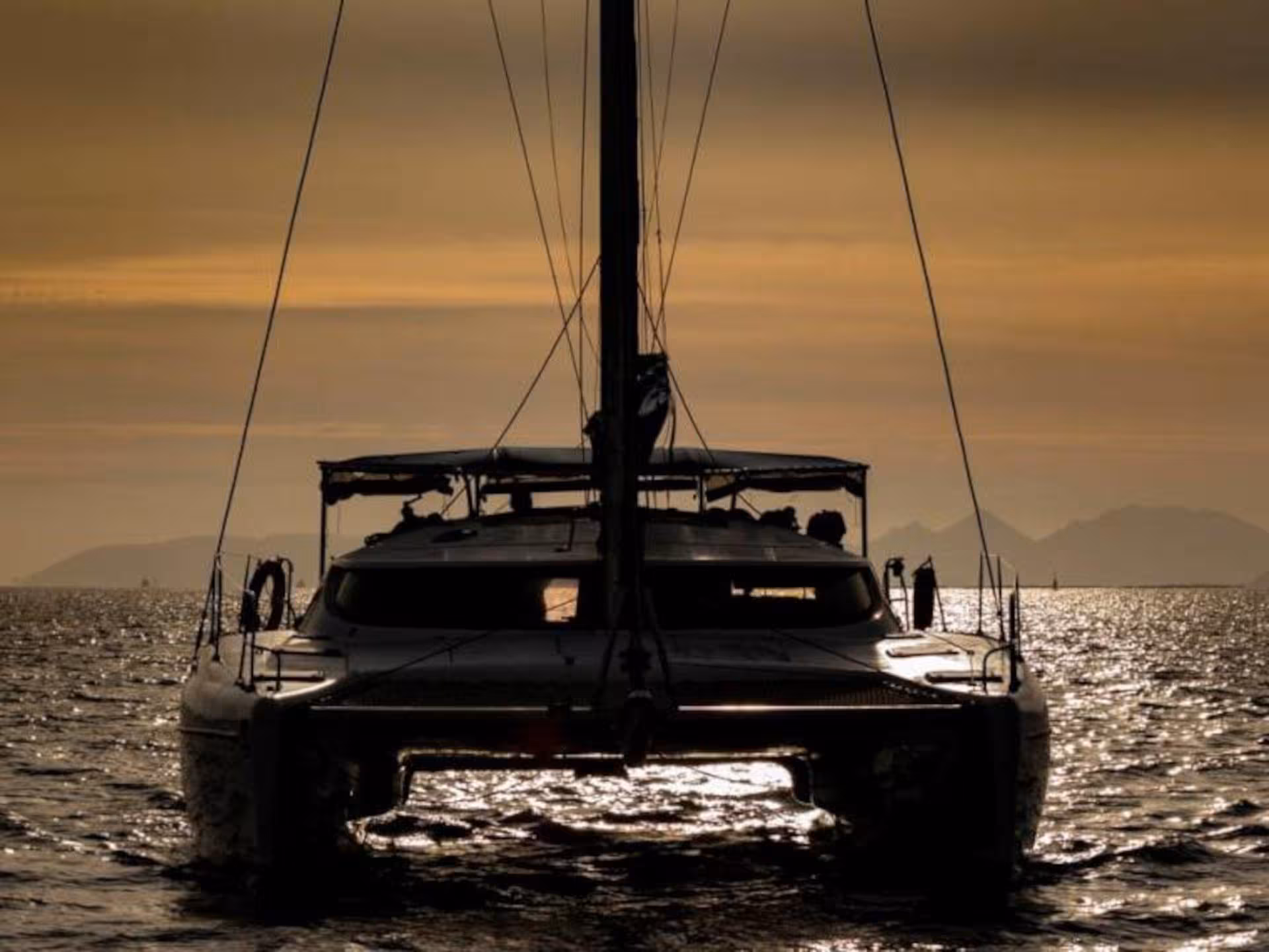 Silhouette of a catamaran sailing at sunset near Cannigione in the La Maddalena Archipelago.