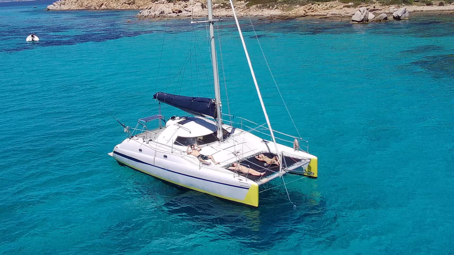 Catamaran anchored in crystal-clear waters near Tavolara, perfect for a serene tour from Olbia to Cala Moresca.