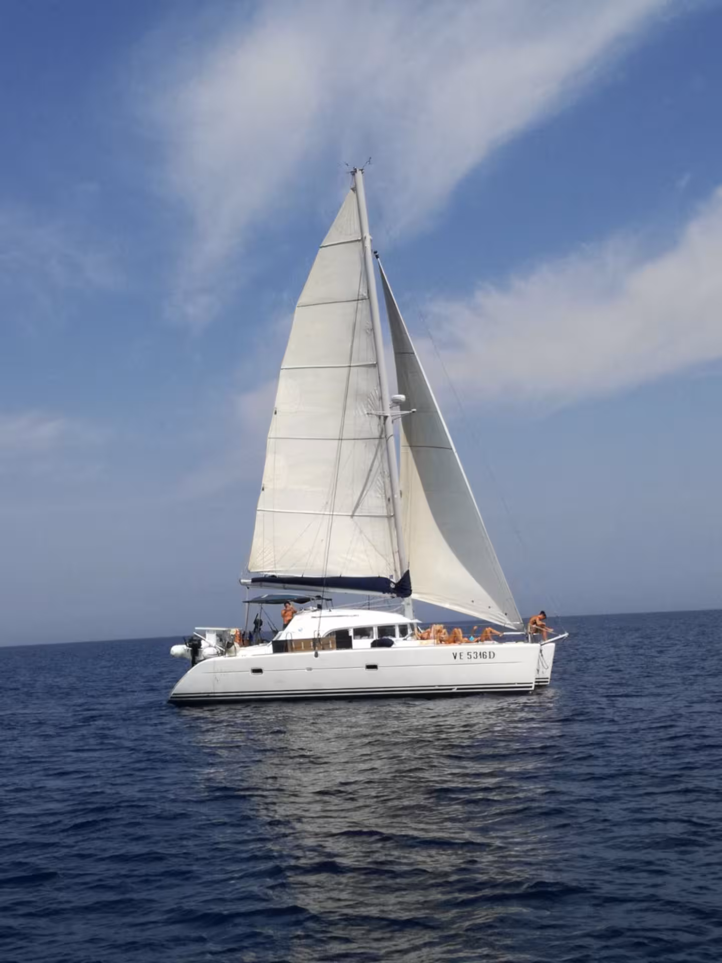 Sailing catamaran Tenerè cruising the clear waters of La Maddalena Archipelago near Cannigione, Italy.