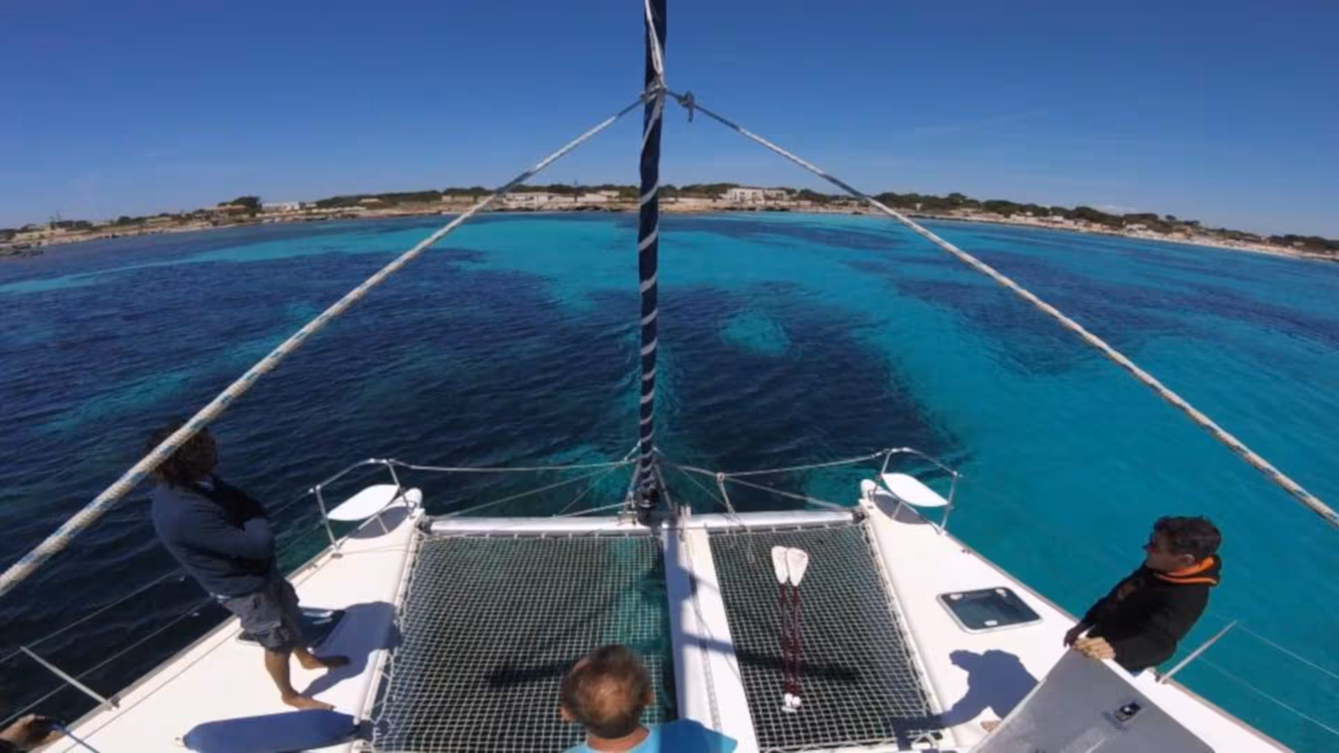 View from the Catamaran Tenerè sailing towards La Maddalena Archipelago, showcasing crystal-clear turquoise waters.
