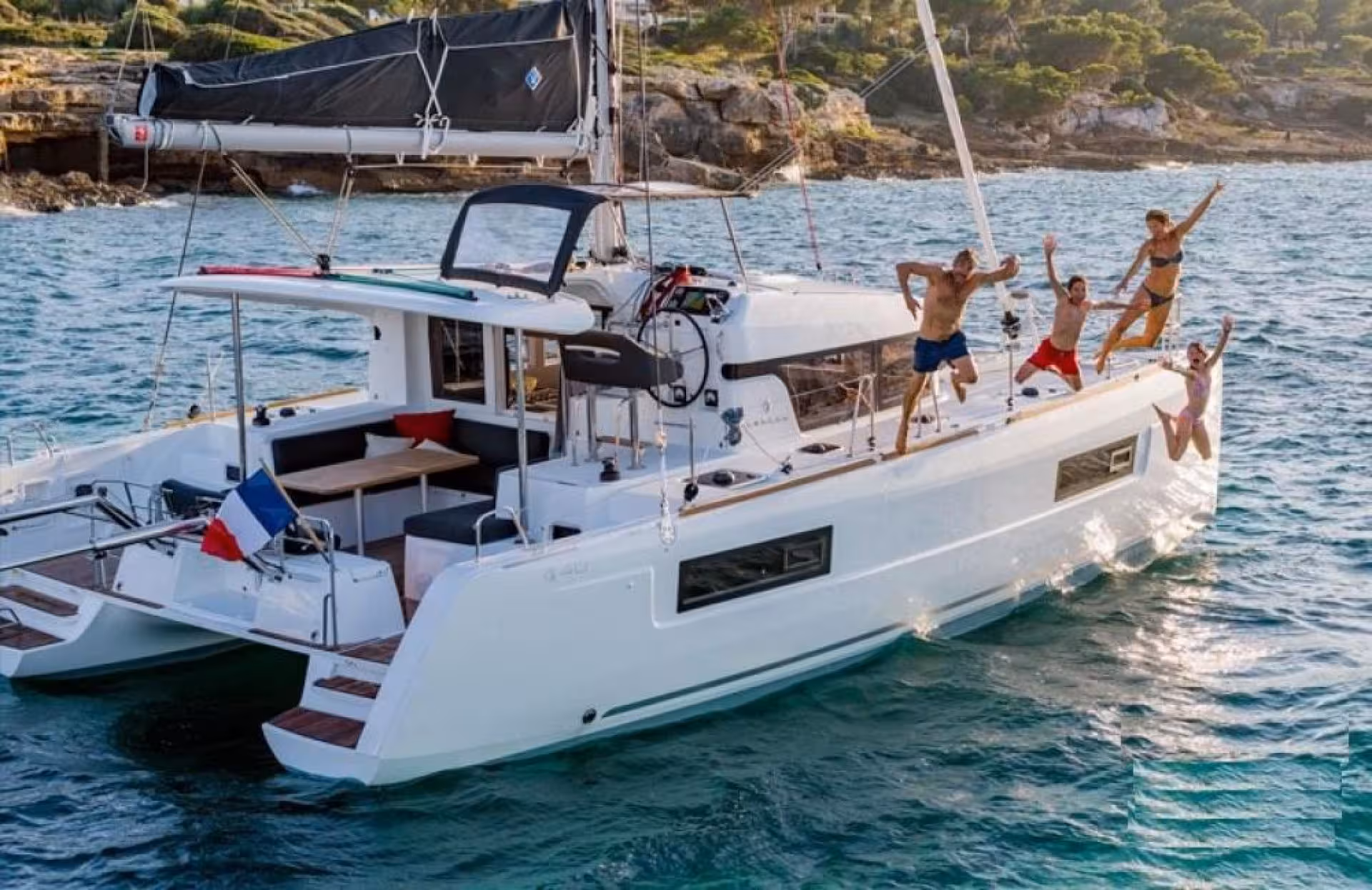 Group of people jumping off a catamaran into the clear waters of La Maddalena archipelago during a Palau tour.